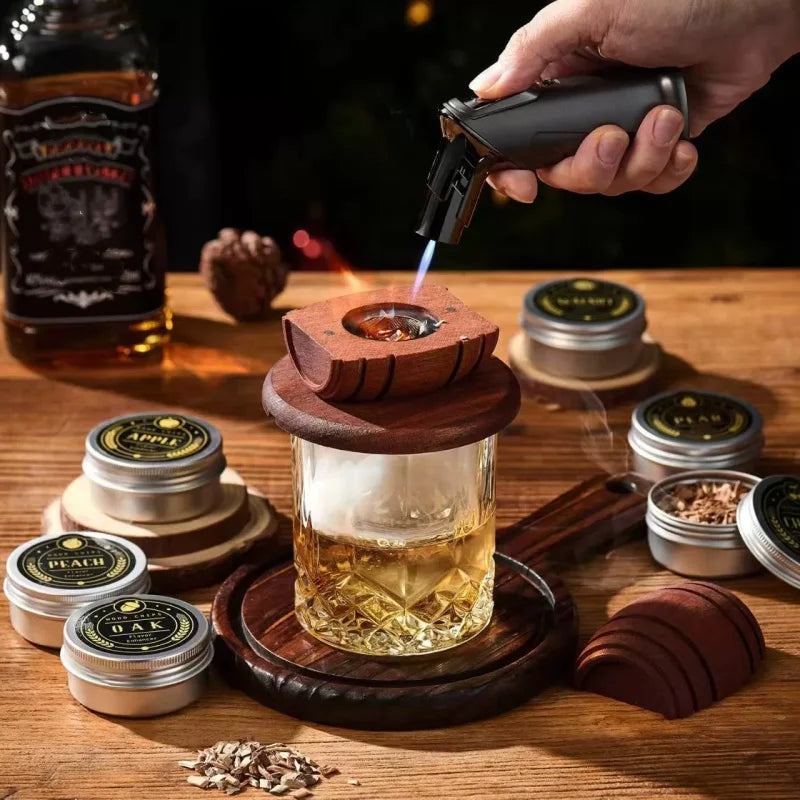 Whiskey Smoker Kit with Wood Chips 6 Flavors being used to add smoke to a glass of whiskey with a torch.